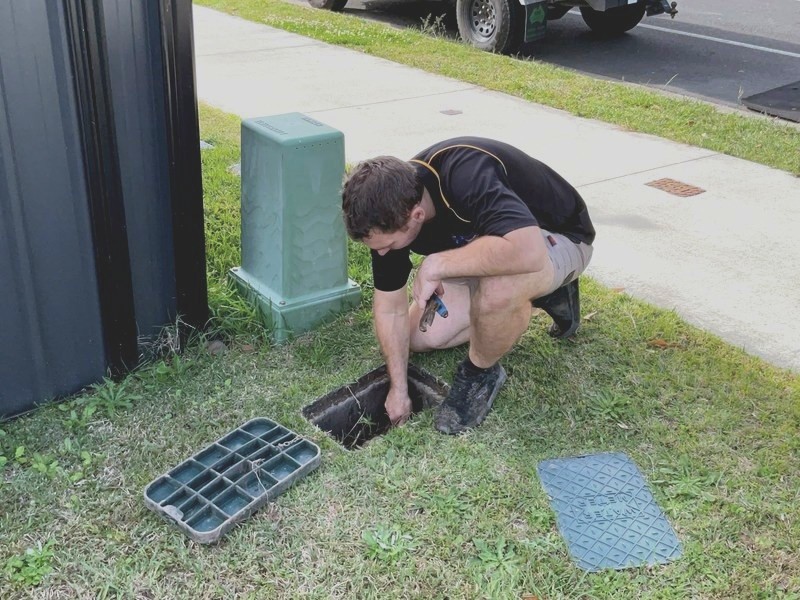 Genies plumber lifting a drain grate